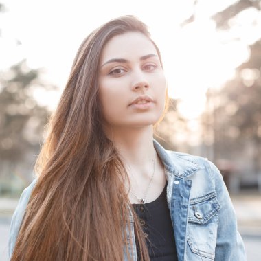 Taze yüzlü, kot ceketli, güzel bir genç kız bahar günbatımında kot ceketli.