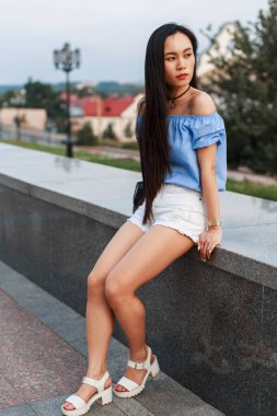 Şehirde şort ve şortla yaz kıyafetleri içinde Asyalı güzel bir manken.