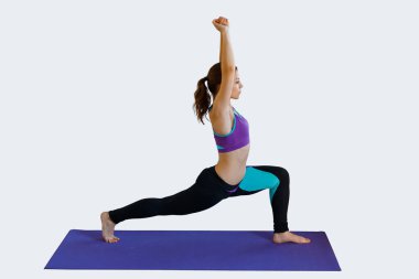 Spor kıyafetli güzel bir kadın spor yapıyor ve arka planda antrenman yapıyor.