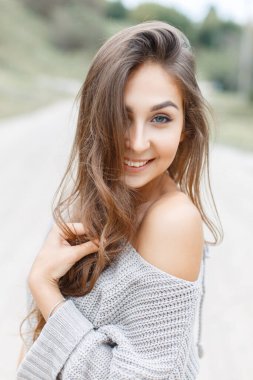 Doğada örülmüş süveter içinde tatlı bir gülümsemesi olan mutlu, güzel, taze bir kadın.