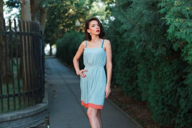 Parkta kırmızı dudaklı, şık, genç ve güzel bir bayan var.