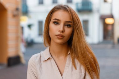 Şık, genç, sarışın, şık yaz kıyafetleriyle şehirde gezen güzel bir kız.