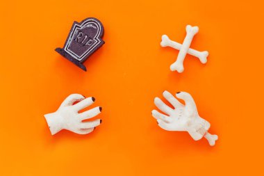 Cadılar Bayramı seti: iskelet, kemikler ve turuncu arka planda mezar. Mutlu Cadılar Bayramı, yaratıcı fikir.