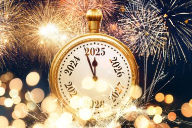 Kaliteli altın saat 2025 yılını işaret ediyor. Işıkları ve havai fişekleri var. Yeni yıl kartı, konsept. Noel, yaratıcı fikir