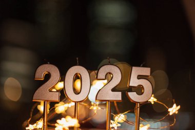 Güzel şenlikli altın 2025 mum ve Bokeh ışıkları yıldızları. Mutlu yıllar 2025