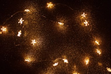 Sarı ışıkları olan güzel, sihirli altın arka plan yıldızları geceleri batıyor. Noel tatili ve yeni yıl duvar kâğıdı