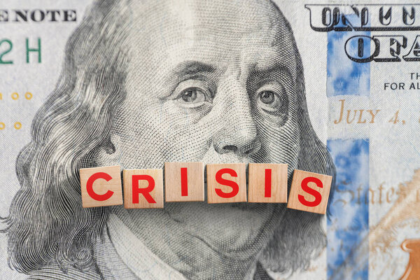 Деревянные кубики Кризис на 100 долларовой купюре, вид сверху. Глобальный экономический кризис, концепция. Экономические и импортные тарифы, креативная идея