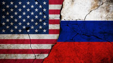ABD ve Rusya 'nın bayrakları, siyasi veya ekonomik gerginliği sembolize eden çatlak bir beton duvarla bölünmüş durumda. Beton çatlamış duvarda çatlaklı Amerika ve Rusya bayrağı