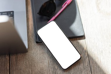 Bilgisayarla birlikte masanın üstünde telefon ekranı var. Serbest çalışanlar, dijital göçebeler veya çevrimiçi girişimciler için konforlu kafe ayarlama ideali.