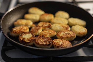 Peynirli krep kızartma tavasında yağlı olarak kızartılır. Yemek pişirme, dersler, konsept. Kahvaltıda yanmış yemek.