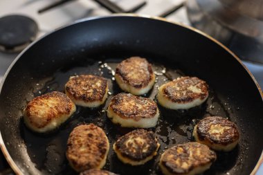 Yanmış peynirli krep kızartma tavasında kızartılıyor, yağlı ve üst manzaralı. Aşçılık ve dersler, konsept