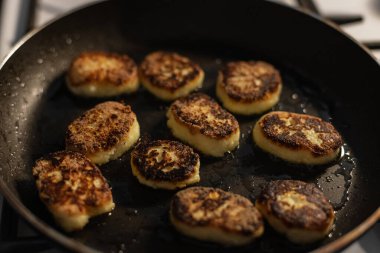 Yanmış peynirli krep kızartma tavasında kızartılıyor, yağlı ve üst manzaralı. Aşçılık ve dersler, konsept