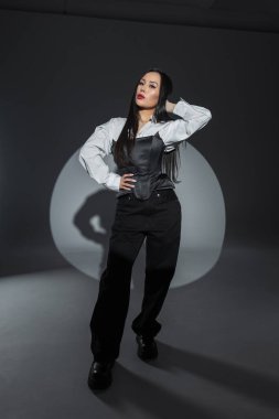 Şık giyinmiş modern bir kadın. Temiz çizgiler, kontrastlı tonlar ve çarpıcı güzellikle moda çekimi. Kırmızı dudaklı güzel Asyalı kadın.