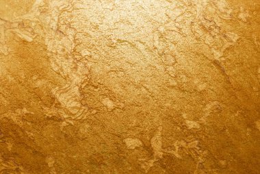 Işıldayan metalik parlaklığı ve doğal taş deseniyle altın desenli yüzey. Lüks tasarım, dekorasyon veya ürün ambalajı için soyut altın arka plan ideali. Altın taş çiğ