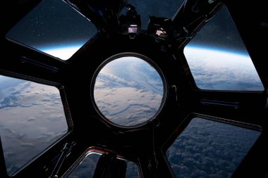 Dünya 'yı uzaydan bir uzay aracı ya da uzay istasyonunun penceresinden görmek. Şaşırtıcı yörünge perspektifi bulutları, kıtaları ve gezegenin eğimini gösteriyor. Keşif elementleri, bilim