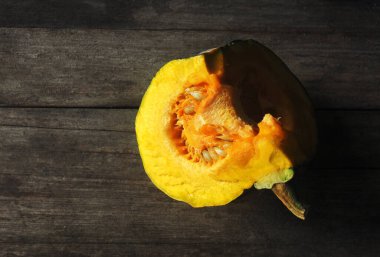 Mutfaktaki ahşap masada yemek pişirmek için yarı sarı balkabağı.