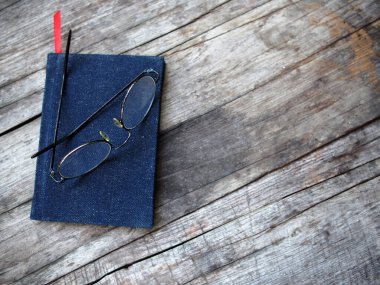 Not defteri ve gözlükler ahşap masaya eski tarz yazar ve okuyucu