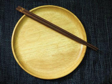 Tahta yemek çubuğu ve bambu hasırında kase.