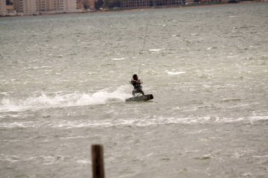 Bir adam denizde motosiklete biniyor.