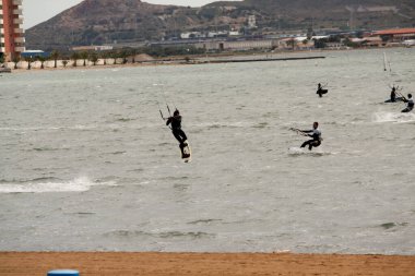 Sahilde takım elbiseli bir sörfçü.