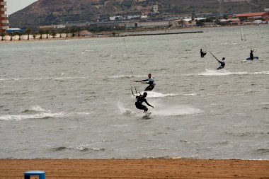 İnsanlar sahilde sörf yapıyor.