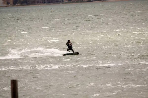 Dalgalarla denizde sörfçü