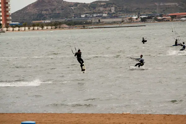 Sahilde takım elbiseli bir sörfçü.