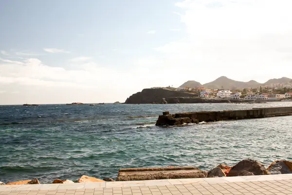 Arka planda deniz ve kaya manzarası.