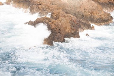 Dalgalar kayalara çarpıyor.