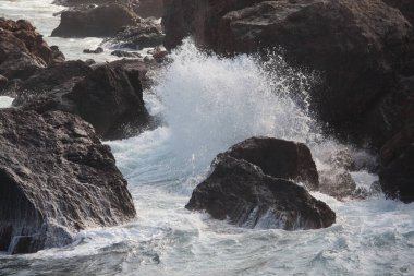 Deniz dalgaları kayalara çarpıyor.