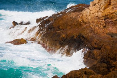 Dalgalar kayalara çarpıyor.