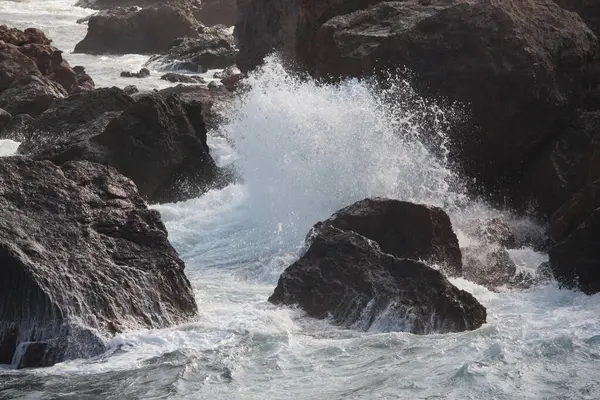 Deniz dalgaları kayalara çarpıyor.