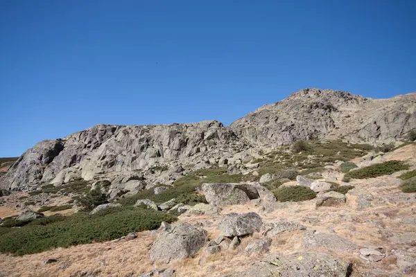 Dağları ve mavi gökyüzü olan güzel bir manzara.