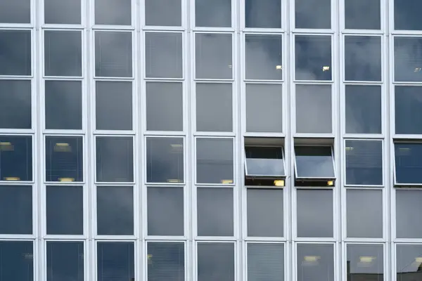 Pencereli ve mavi bulutlu gökyüzü olan ofis binası