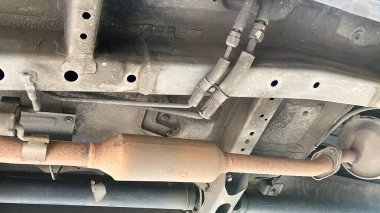 Katalitik dönüştürücü. Modern araba alt görüşünün egzoz borusu sistemi. Paslı ve kirli araba parçaları, kaldırılmış araba parçaları.