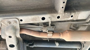 Katalitik dönüştürücü. Modern araba alt görüşünün egzoz borusu sistemi. Paslı ve kirli araba parçaları, kaldırılmış araba parçaları.