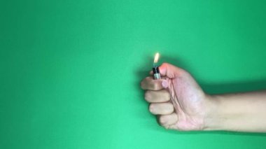 Çakmağı olan bir erkek. Adam ateş, çakmak gazı ve bir el videosu yapıyor. yeşil ekran arkaplanı.