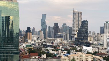 Bangkok şehir manzarası. Arkasında nehir ve binalar olan bir şehir.