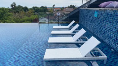 Yüzme havuzu, beyaz güneş yatakları ya da yan tarafında şezlong.