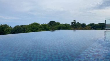 Sonsuz yüzme havuzu, mavi bir su ve Bali 'de arka planda ağaçlar
