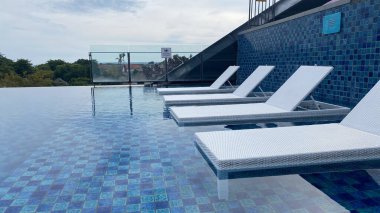 Yüzme havuzu, beyaz güneş yatakları ya da yan tarafında şezlong.