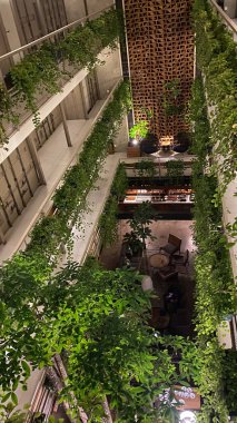 Otel mimarisi. Duvarında saksı var. Ortasında boşluk var.