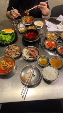 Kore bayrağıyla dolu bir masa havuç ve soğan da dahil olmak üzere bir sürü yemek tabağı Kore yemeği.