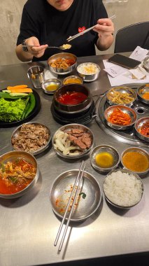 Kore bayrağıyla dolu bir masa havuç ve soğan da dahil olmak üzere bir sürü yemek tabağı Kore yemeği.