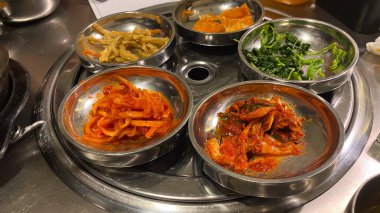 Kore bayrağıyla dolu bir masa havuç ve soğan da dahil olmak üzere bir sürü yemek tabağı Kore yemeği.