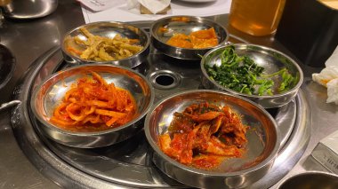 Kore bayrağıyla dolu bir masa havuç ve soğan da dahil olmak üzere bir sürü yemek tabağı Kore yemeği.