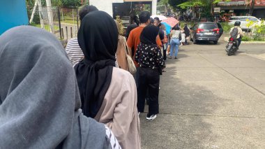 Bir mağazada kuyrukta bekleyen bir sürü insan var. Virüs dükkanında kuyruk