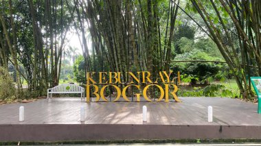 Botanik Bahçesi veya Kebun Raya Bogor ön işareti, çeşitli kökenden 13.983 farklı ağaç ve bitki çeşidi içerir. Arka planda bambu planı var.