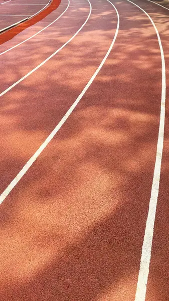 Kırmızı sentetik lastik koşu yolu. Sentetik koşu şeridi açık hava sporu için.