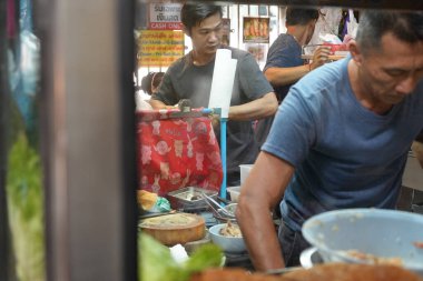 Bangkok, Tayland - 16 Kasım 2024: Raan Yaam Jae-Euang 'ın mutfağında yemek pişiren adam, Chatuchak Haftasonu Marketi' nin ünlü yerel mutfağı, yemek yemeye gelen insan ve turistlerle dolu.